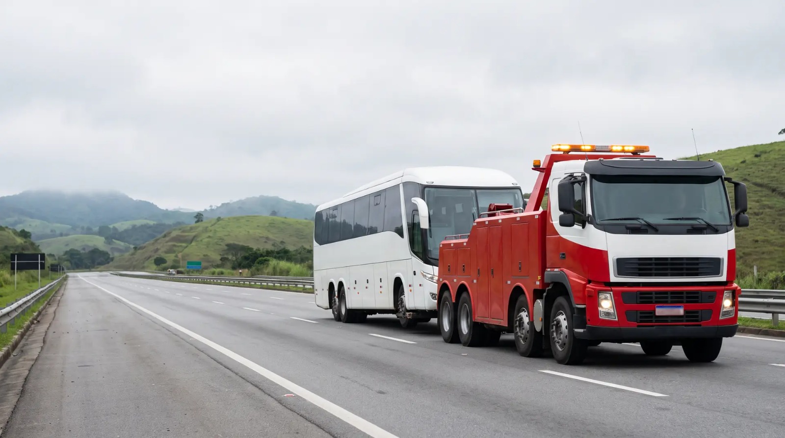 Guincho pesado rebocando um ônibus rodoviário na rodovia